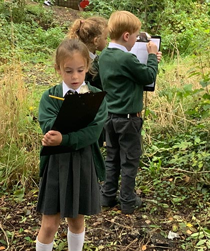 Children outside with clipboards